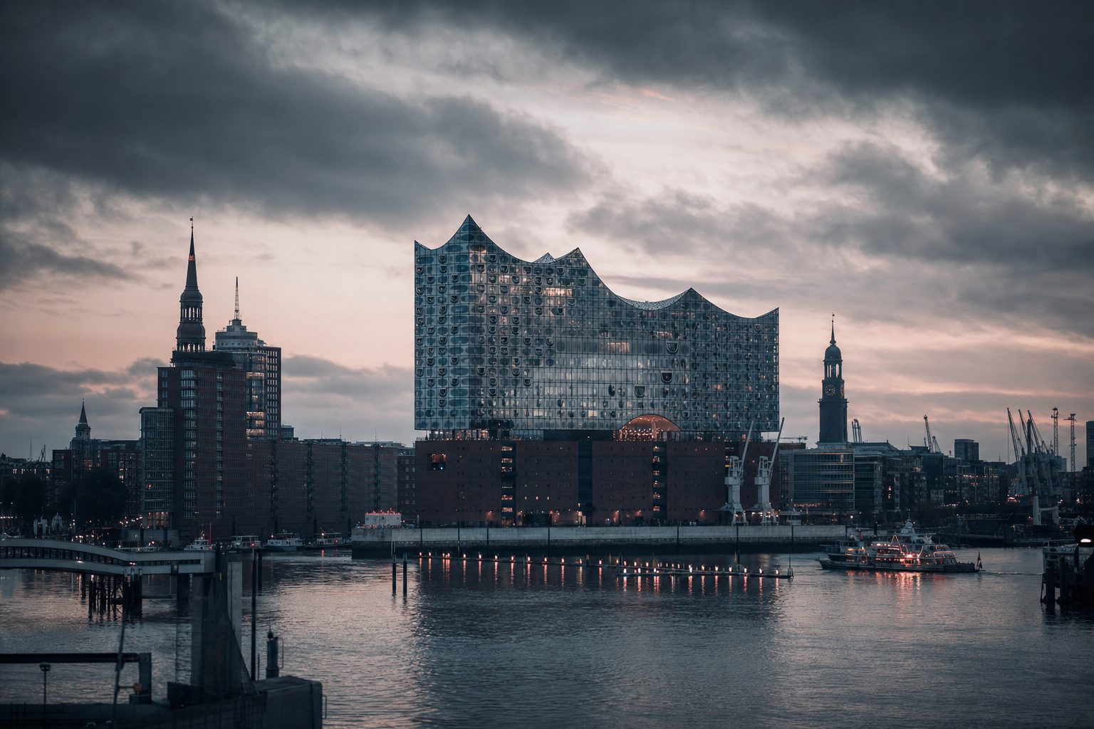 Hamburger Stadtsilhouette mit der Elbphilharmonie und den Backsteindächern der Speicherstadt im Abendlicht